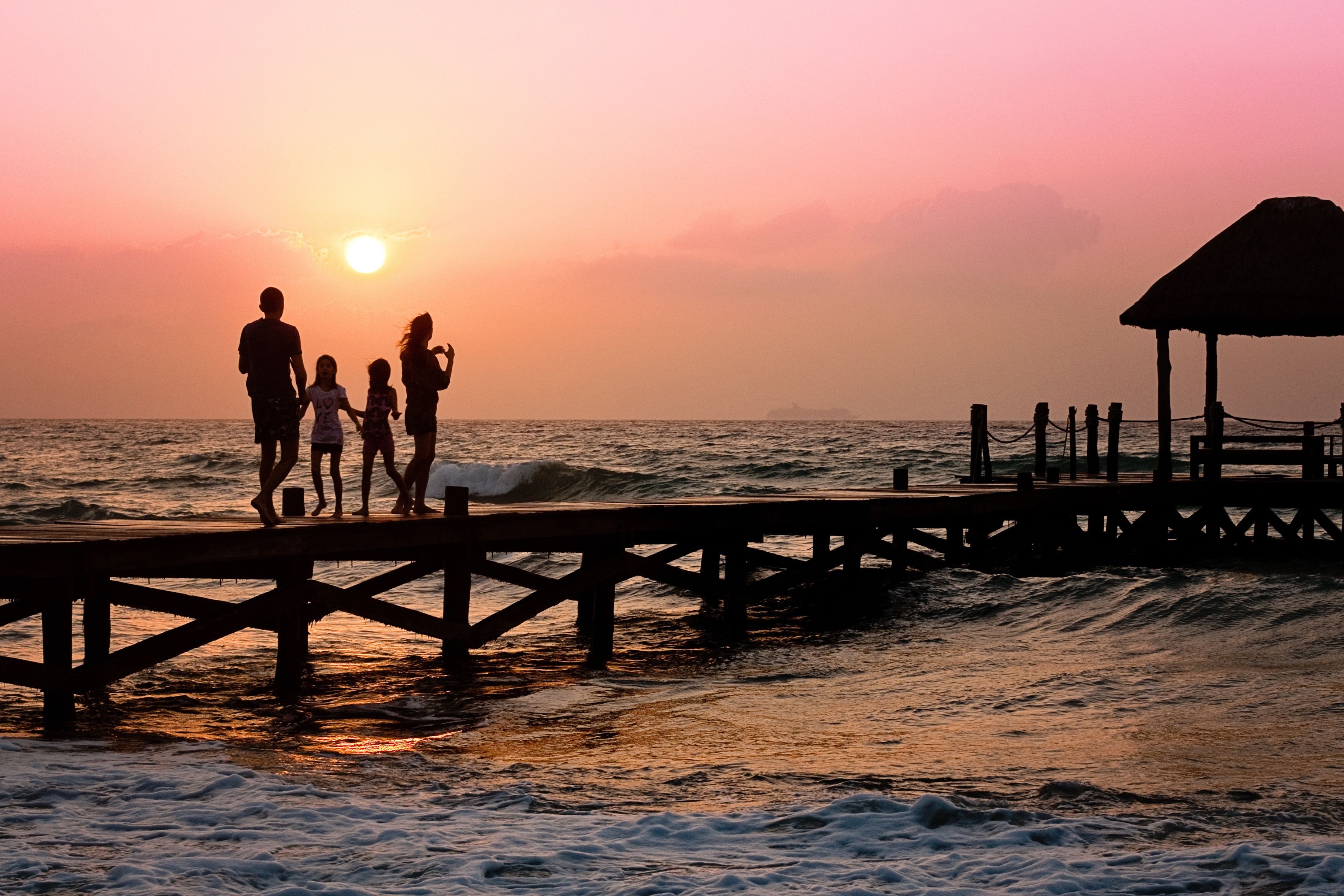 Image showing a family walking on a pier at sunset